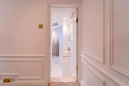 切尔滕纳姆Elegant 3 bedroom home in the centre of Cheltenham的走廊上设有通往浴室的门