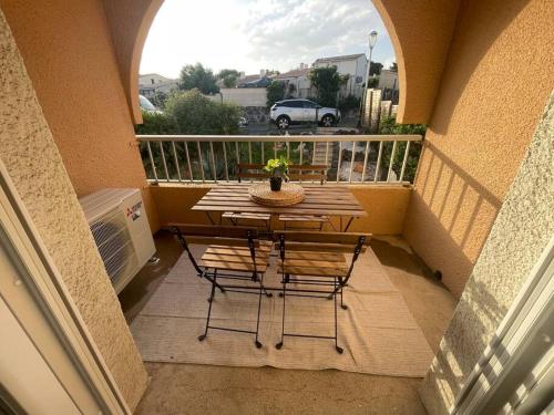 阿格德角Appartement Cap d'Agde dans résidence avec piscine的阳台配有桌椅。