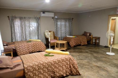 MfuweKUDU SAFARI LODGE (Mfuwe, Zambia)的一间设有三张床的房间和一间设有房间的房间