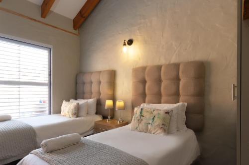 乔治Owls Nest Self Catering的一间卧室设有两张床和窗户。