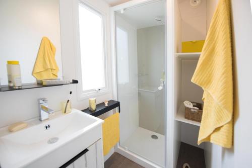 卢尔德CAMPING PLEIN SOLEIL的浴室配有白色水槽和淋浴。