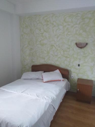 PrăjilaPensiunea Madalina - LIMARA的一间卧室配有一张带白色床单和墙壁的床。