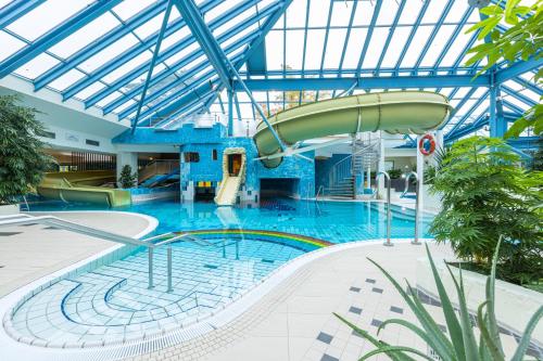 宾茨IFA吕根岛度假酒店的大楼内一个带滑梯的大型游泳池