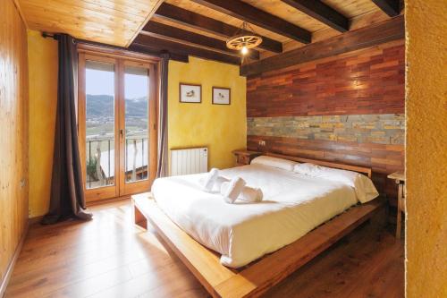 普奇塞达Masia d'en cot的一间卧室设有一张带木墙的大床