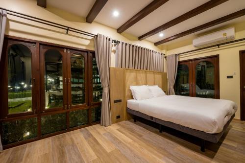 Ban Lao Kok KhoMiranda's House Khaokho มิรันดาเฮ้าส์ เขาค้อ的一间卧室设有一张床和一些窗户。