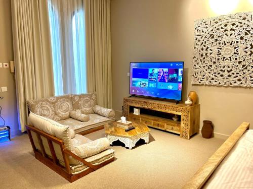 利雅德شاليه مثوى الصباريات的客厅配有电视、沙发和椅子