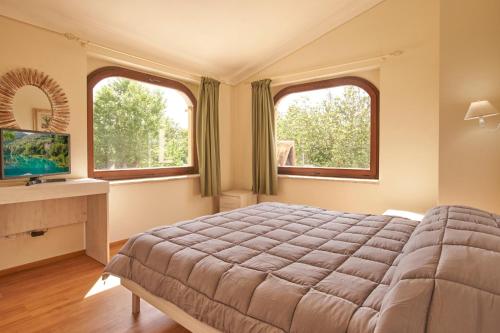 福利尼奥CASALE SUL CLITUNNO的一间卧室设有一张大床和两个窗户。