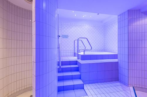 舍内克IFA舍内克洛普森酒店&度假村的浴室设有蓝色瓷砖楼梯和浴缸。