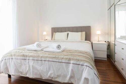 雅典Faliro 2 Bd Escape Modern Living Redefined的卧室配有带毛巾的大型白色床