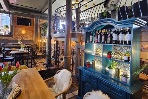 沃姆扎潘思捷耐特复古酒店的餐厅设有蓝色架子,提供葡萄酒