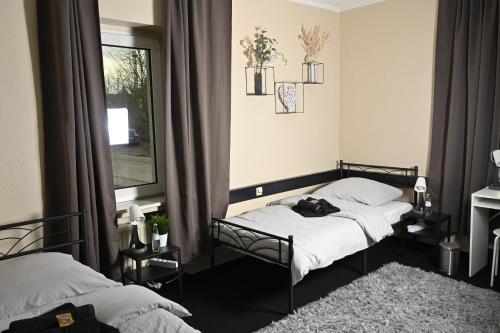 埃森Pott Hostel - Zimmervermietung的一间卧室设有两张床和窗户。
