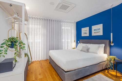 波尔图波尔图画廊住宿加早餐旅馆的一间卧室配有一张带蓝色墙壁的大床