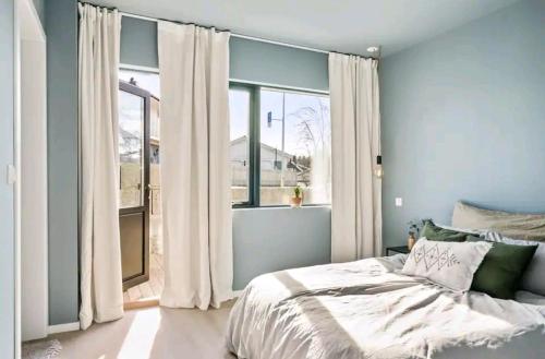 桑讷菲尤尔Modern house near the ocean的一间卧室设有一张床和一个大窗户