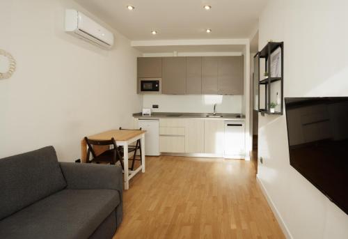 比亚努夫拉Villanubla Apartaments的带沙发和桌子的客厅以及厨房。