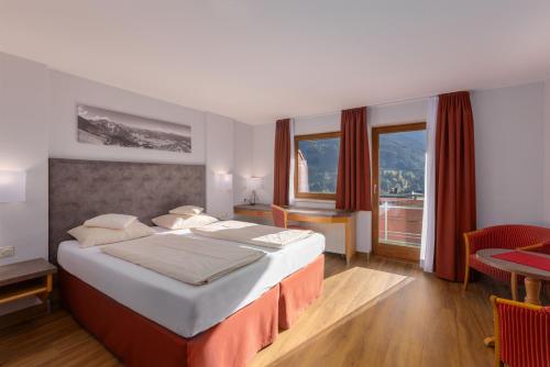 米特尔贝格克林瓦萨特IFA阿尔彭罗斯酒店的酒店客房设有一张大床和一张桌子。