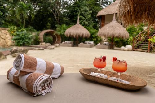 莫雷洛斯港Oom Bubble Boutique Riviera Cancun的桌上的一条毛巾和两杯鸡尾酒