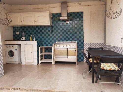 洛美La Résidence的厨房配有炉灶和桌子。