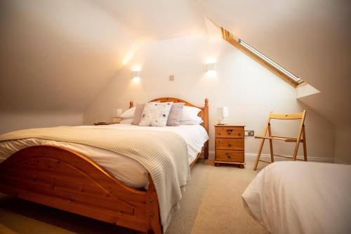 AllantonPurves Cottage的一间卧室配有一张木床和一把椅子