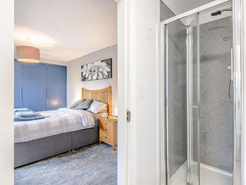 Ffestiniog4 Bed in Porthmadog 81060的一间卧室设有一张床和一个玻璃淋浴间