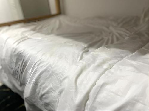 阿布扎比Abu Dhabi Center - Unique Bed Space的一张未铺好的床铺,上面有白色的床单