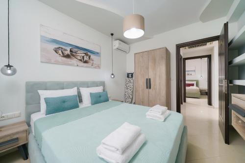斯卡拉马里昂Tarsa's House by the Sea的一间卧室配有蓝色的床和毛巾