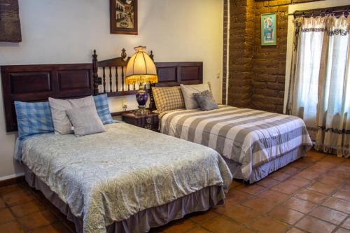 ZitácuaroSolache Inn的一间卧室配有两张床和一盏灯