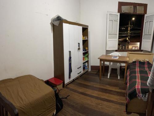 欧鲁普雷图Quarto inteiro, próx ao Centro - República Saideira的客房设有床、书桌和橱柜。
