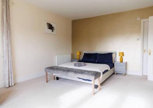 佩恩斯威克Perfect Cotswold Home with vast stunning Ground's的一间卧室配有一张床,其中配有长凳