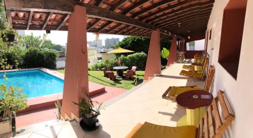 萨尔瓦多Point do Rio Vermelho的庭院设有游泳池、桌子和椅子。