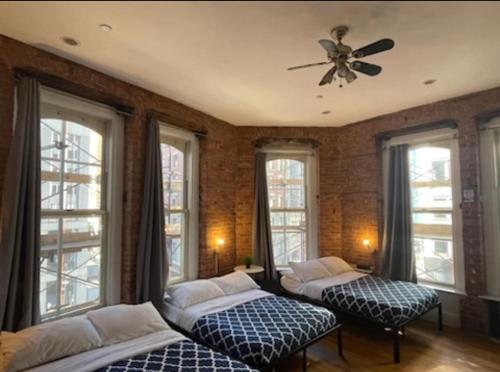 纽约Midtown Nest Studio Self Serviced Apartment Sleeps 5的配有窗户和吊扇的客房内的两张床