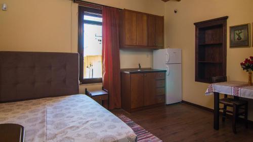 Dhamavólosvilla Morfeas的客房设有带一张床和一台冰箱的厨房