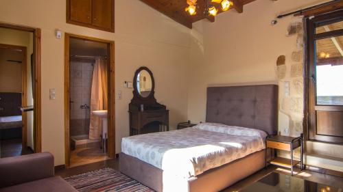 Dhamavólosvilla Morfeas的一间卧室配有一张床和镜子