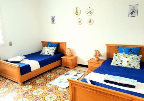 拉马萨The Marsa story的蓝色和白色的客房内的两张床