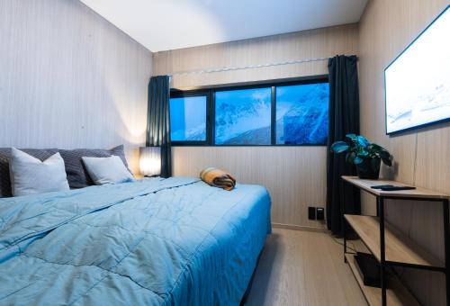 KleppstadNew luxury cabin near Henningsvær Lofoten的一间卧室设有蓝色的床和2个窗户。