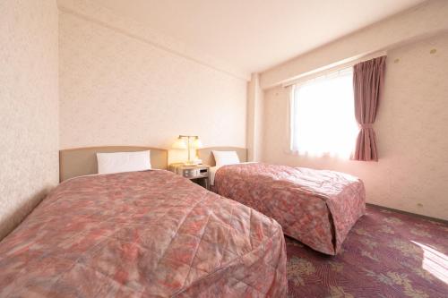 都城市Main Hotel - Vacation STAY 85409v的酒店客房设有两张床和窗户。
