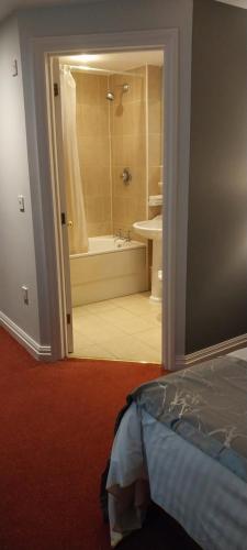 沃金厄姆The Emmbrook Inn Hotel的一间卧室设有1间带浴缸和淋浴的浴室