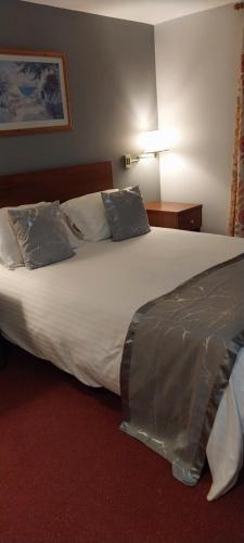 沃金厄姆The Emmbrook Inn Hotel的一张大白色的床,位于酒店客房内