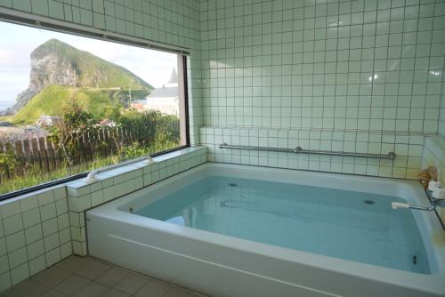 鸳泊Shimano Yado Kamuirishiri - Vacation STAY 89683v的带浴缸的瓷砖浴室设有窗户