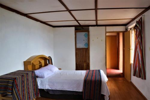 HuillanopampaINKA LAKE Taquile Lodge的卧室配有一张床
