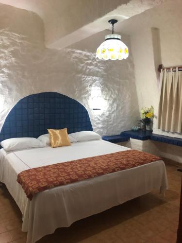 伊斯塔帕Suit Junior Emano 410的一间卧室配有一张大床和蓝色床头板