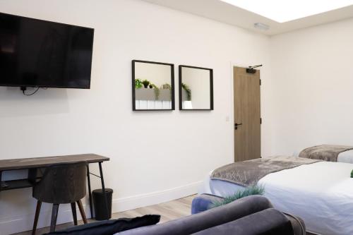 BedlingtonMood Apartment 4的一间卧室配有一张床,墙上配有电视