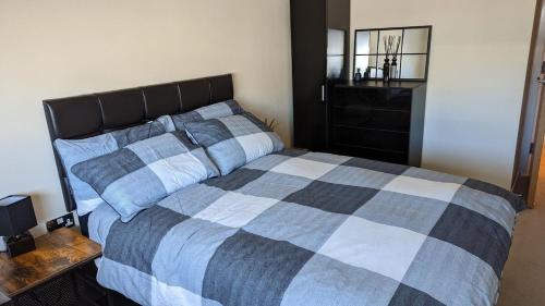 利兹Excellent Leeds City Centre 1 Bedroom Apartment的一间卧室配有一张带 ⁇ 子毯子的床