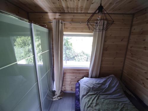 杰泽扎尼Domki nad morzem i jeziorem的小木屋内的卧室,设有窗户