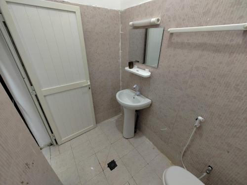 吉布提Miguil House的一间带卫生间、水槽和镜子的浴室