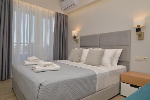 奥林匹亚基·阿克蒂Olympus Diamond studios的一间卧室配有一张大床和毛巾