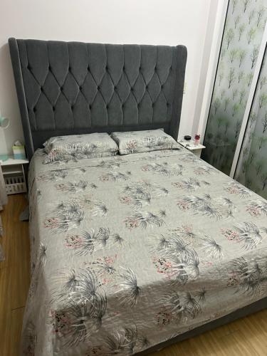 马尼拉RJMR Acqua private residence的一间卧室配有一张带花草床罩的床