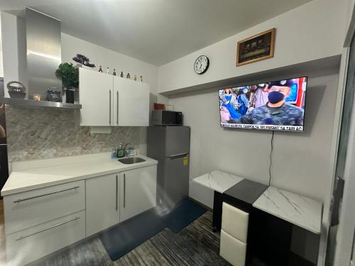 马尼拉RJMR Acqua private residence的墙上配有电视的小厨房