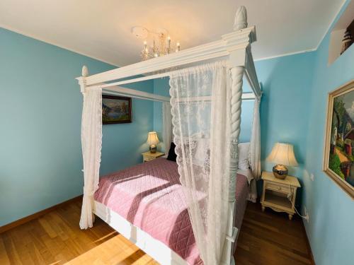 泰拉西尼Esmaraldas House of Love的一间卧室设有天蓬床和蓝色的墙壁。