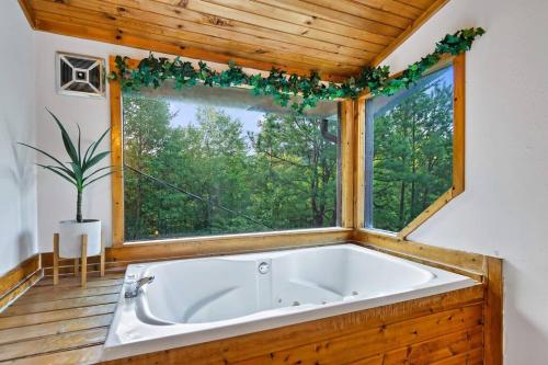 鸽子谷NEW HOT TUB! Secluded 3 Bed Cabin in Pigeon Forge的窗户客房内的大浴缸