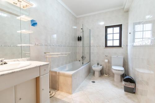 圣特奥托纽La Familia House的带浴缸、卫生间和盥洗盆的浴室